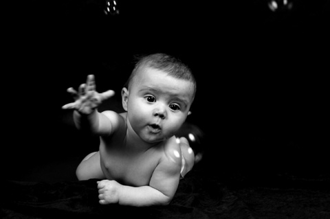 baby seifenblasen fangend, schwarzweiss foto