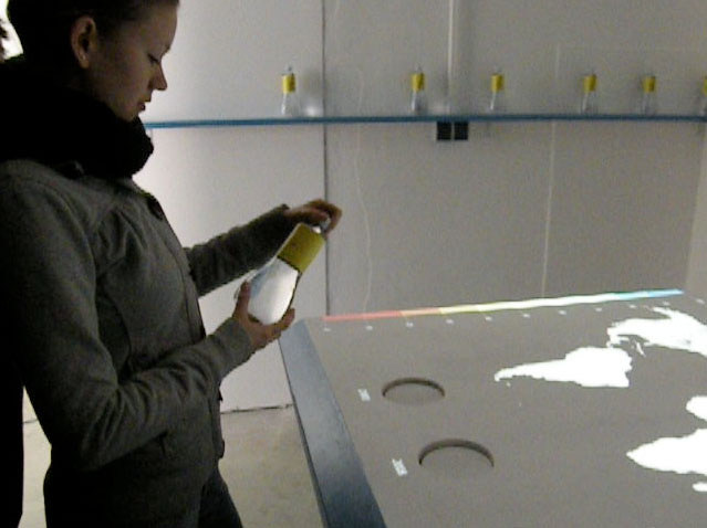Eine Besucherin studiert die Gebrauchsanleitung auf der WORLDWATER-Flasche