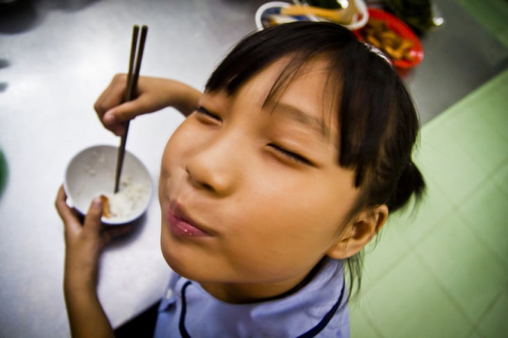 A girl enjoys a meal cooked for her at a children’s centre in Saigon, Vietnam.