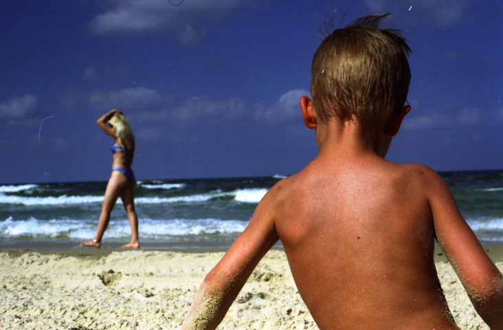 Kind am Strand mit blonder Frau