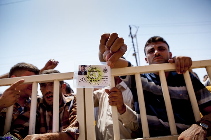 refugee holding a ID and waiting for relief items