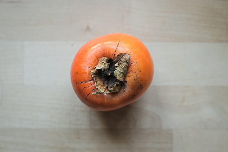 Persimmon fruit on wooden background.