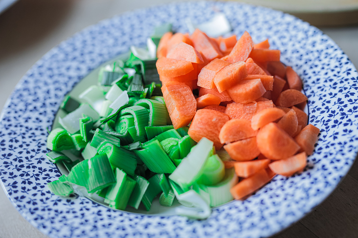 Carrots and leeks cut on a plate.