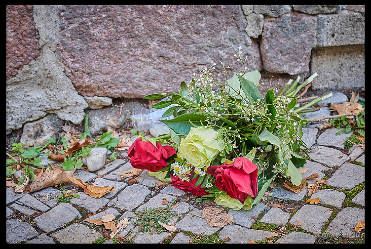 Bouquet of flowers fallen over by the wind next to the entrance door of the synagogue.