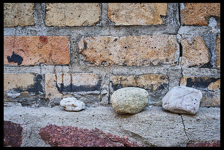 Drei Steine liegen auf dem Mauervorsprung neben der Tür zur Synagoge
