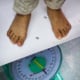 A child being weighed at a health clinic sponsored by UNICEF