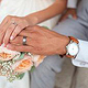 Hochzeitspaar mit Händen und Blumenstraus