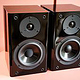 Black, high quality loudspeaker boxes against a colored background.