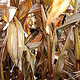Ein Maiskolben zwischen trockenen Blättern und Stämmen