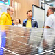 Solarpanel mit Standbesuchern im Hintergrund